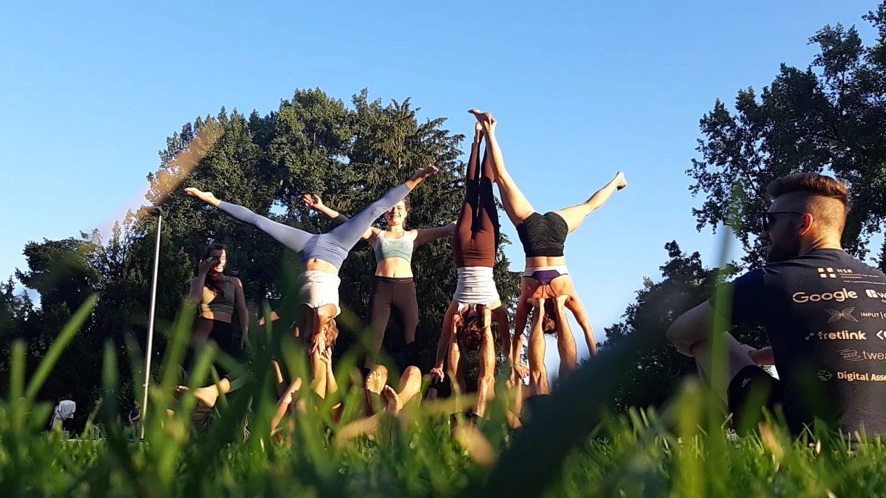 People practicing acroyoga in the grass