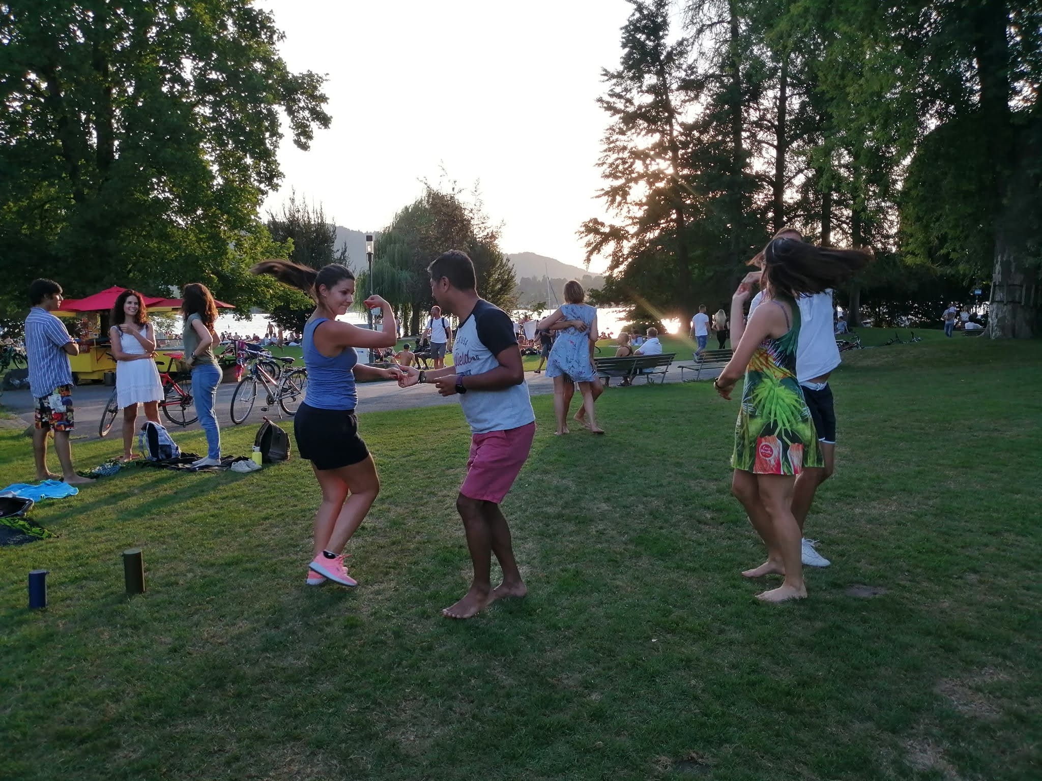 People dancing next to a lake